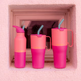 Klean Kanteen pink lemonade kaleidoscope 16oz, 26 oz and 36oz rise insulated stainless steel bottle and tumblers standing in front of a window showing the pink colour way and handle detail on the tumblers