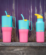 Klean Kanteen turquoise kaleidoscope 16oz, 26oz and 36oz rise insulated stainless steel bottle and tumblers on a stone surface showing the pink and turquoise colour way design and handle detail on the tumblers