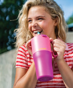 A young adult holding the 26oz pink lemonade kaleidoscope 26oz Klean Kanteen rise insulated stainless steel tumbler by the handle on the side showing the scale