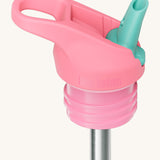 A close up of the Klean Kanteen pink and turquoise flip sports straw cap for the rise insulated bottle showing the turquoise spout and small loop detail.