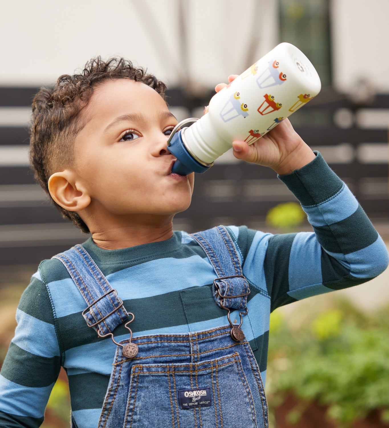 A child drinking from a car print Kid Kanteen 12oz Narrow Sippy Bottle.