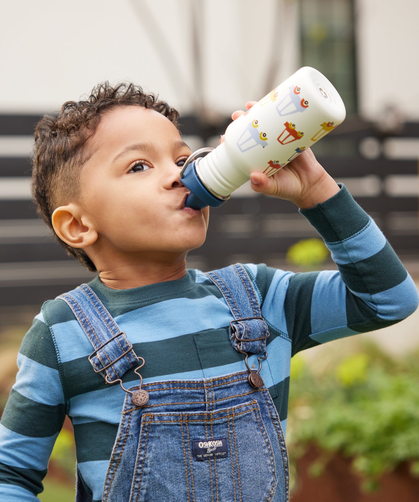 A child drinking from a car print Kid Kanteen 12oz Narrow Sippy Bottle.