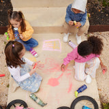4 children sitting on a concreate path drawing with chalks, four different Kid Kanteen can be seen. One child is drinking out of a mushroom print sippy cap Kid Kanteen. There are 3 other Kid Kanteen on the ground next to the children, an insulated Ice Cream print bottle, an insulated Mountain Range bottle and a Milky Way print bottle.