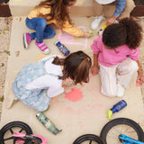 Children sitting on a concrete path drawing on the path with chalks. There are Kid Kanteen reusable water bottles on the ground next to the children.