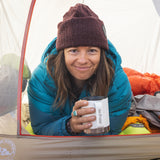 An adult enjoying a drink from their Klean Kanteen 12oz Insulated Camping Mug in White