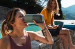 Close up of woman drinking from a Klean Kanteen stainless steel drinks tumbler next to a stone wall