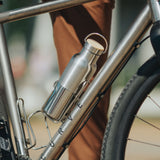 A klean Kanteen 16oz reflect stainless steel Klean Kanteen insulated bottle in bottle holder on a bike.