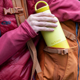A close up of a adult hand holding on the acacia 20oz Klean Kanteen rise water bottle showing the matching loop cap detail.