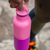 A adult hand holding the pink lemonade 20oz Klean Kanteen Reusable Stainless Steel Water Bottle