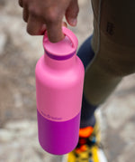 A adult hand holding the pink lemonade 20oz Klean Kanteen Reusable Stainless Steel Water Bottle