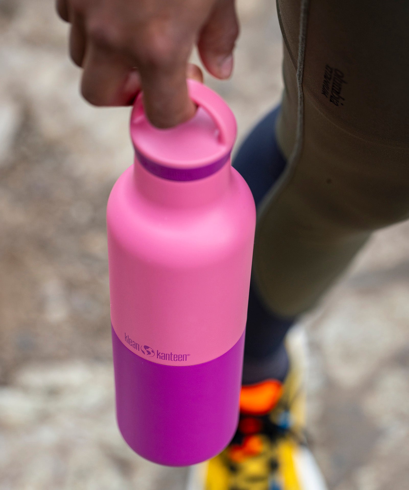 A adult hand holding the pink lemonade 20oz Klean Kanteen Reusable Stainless Steel Water Bottle