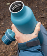 A adult hand holding the Brittany blue 20oz Klean Kanteen Reusable Stainless Steel Water Bottle with the loop cap off and showing the inside thread detail