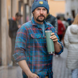 A man holding a sea spray green coloured Klean Kanteen 20oz TKWide Cafe.