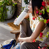 A person drinking from a tofu white coloured Klean Kanteen 20oz TKWide .