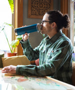 A person drinking from a corsair blue coloured Klean Kanteen 20oz TKWide .