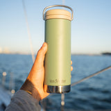 A close up of a person holding up a sea spray green coloured Klean Kanteen 20oz TKWide .