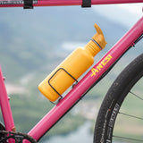 A Sunset yellow coloured Klean Kanteen 27oz Classic Narrow Flip Seal Sports Cap Reusable Stainless Steel Water Bottle placed in a bottle holder of a pink coloured bike. .