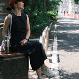 A woman sitting on a bench and holding the Klean Kanteen rise stainless steel bottle with bamboo lid. Bottle available at Babipur.