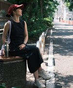 A woman sitting on a bench and holding the Klean Kanteen rise stainless steel bottle with bamboo lid. Bottle available at Babipur.