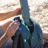 A person is putting the Klean Kanteen bottle with a flip seal sports cap in their bag, with the bottle upside down to demonstrate how it's a leakproof cap.