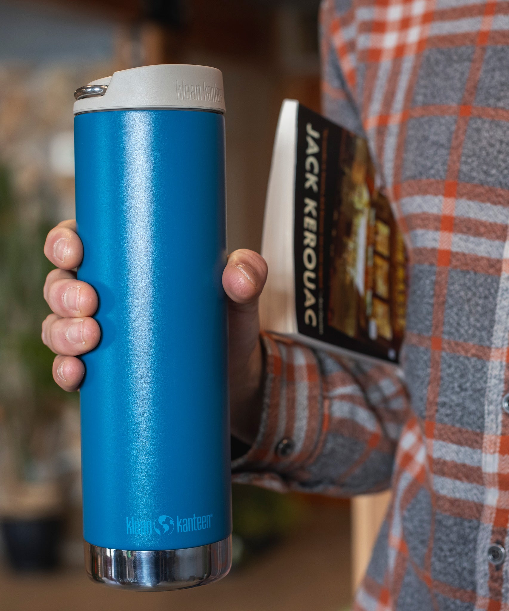 A close up of a person holding the cosiar blue coloured Klean Kanteen 20oz TKWide Cafe in their hand.