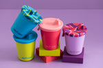 4 Klean Kanteen kids 10oz steel drinks cups with the removable sippy lid on a purple background