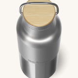 A close up of the Klean Kanteen 16oz reusable stainless steel reflect water bottle available at Babipur showing the bamboo detail on top of the loop cap.