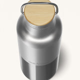 A close up of the Klean Kanteen 16oz reusable stainless steel reflect insulated bottle available at Babipur showing the bamboo detail on top of the loop cap.
