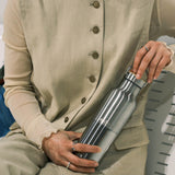 A woman holding a klean Kanteen 16oz reflect stainless steel insulated bottle showing the scale and finish detail