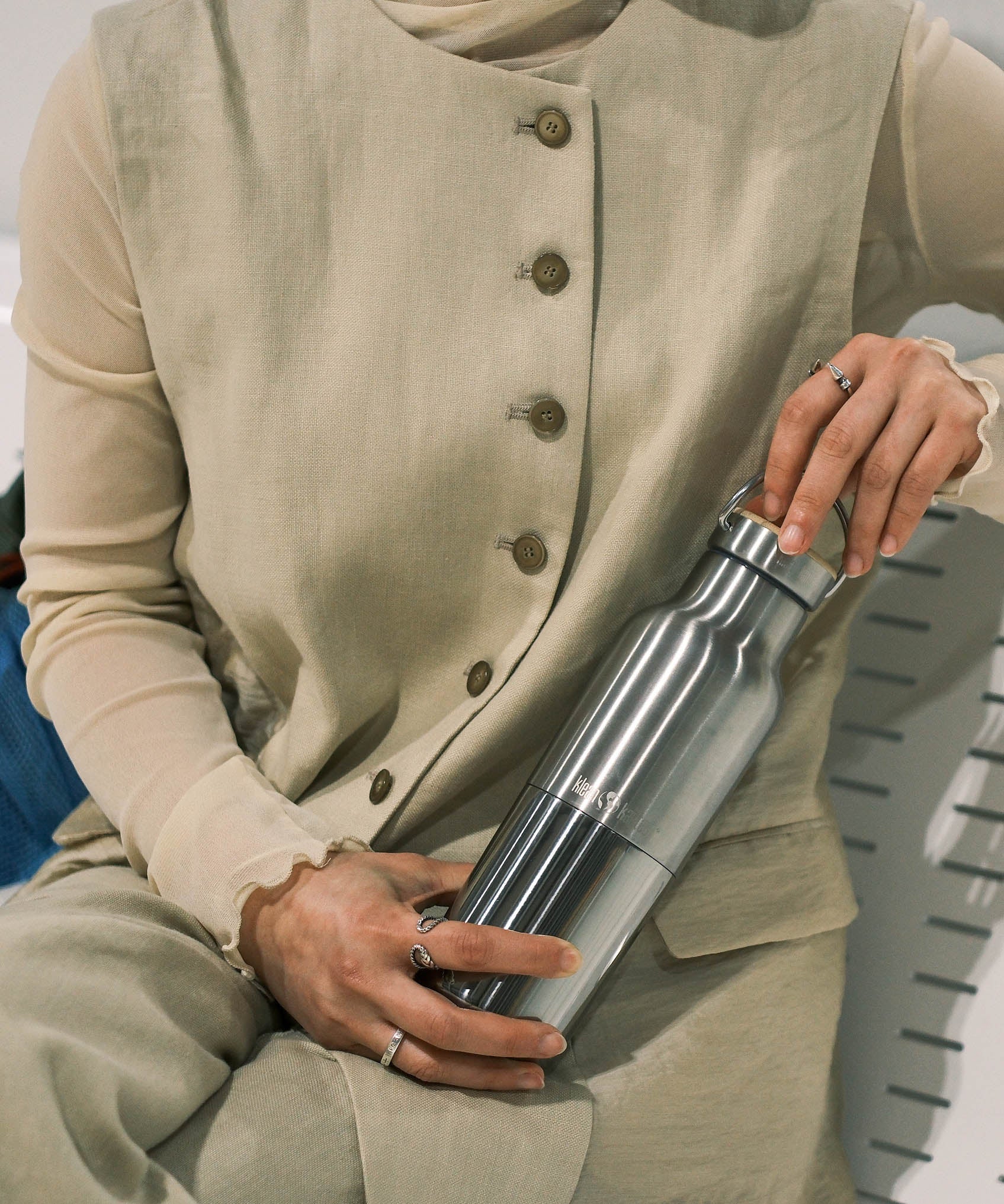 A woman holding a klean Kanteen 16oz reflect stainless steel insulated bottle showing the scale and finish detail