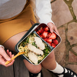 Klean Kanteen Rise Stainless Steel Meal Box with divider at 1/3 holding a salad in one section and strawberries in the other