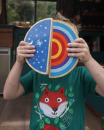 Boy holding up the Lanka Kade Babipur dan y ser and machlud haul toys in front of his face