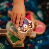 Close up of hand grabbing the Lanka Kade purple ram animal toy on a dan y ser playmat