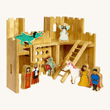 Back view of the wooden Lanka Kade castle with the fairytale wooden figures. Showing the corner walls with window holes, the lowered drawbridge and gate with a ladder that connects the ground floor and 1st floor