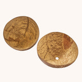 A close up of the coconut bowls from the coconut sand play set showing the 2 shells with a hole in the bottom in one shell for sand to pour through