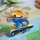 A stack of Lanka Kade toy figures with the icthyosaur placed on top of a utahraptor and mososaurus. These wooden toy figures are part of a huge range of Lanka Kade fair trade, wooden toys available here at Babipur.