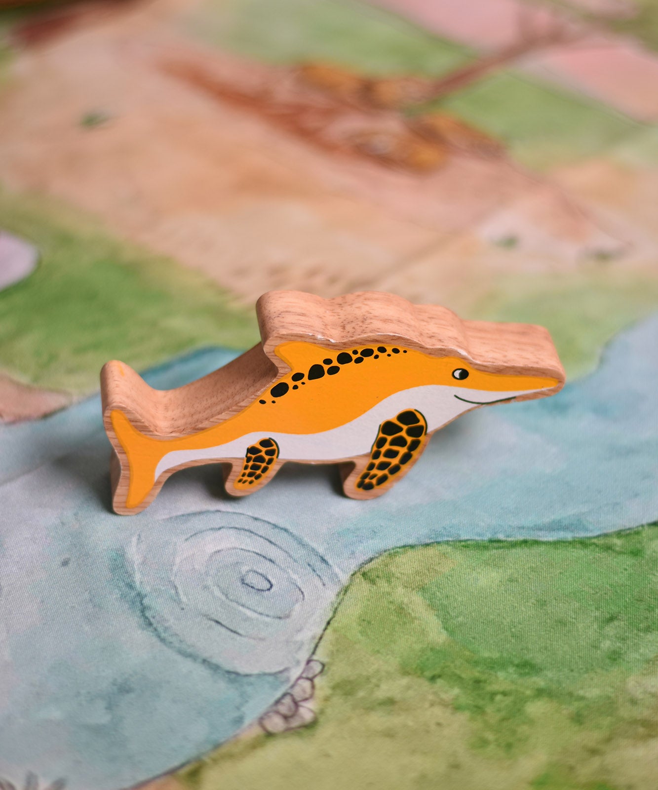 A Lanka Kade icthyosaur placed on a Wonderie play cloth. These wooden toy figures are part of a huge range of Lanka Kade fair trade, wooden toys available here at Babipur.