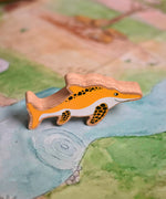 A Lanka Kade icthyosaur placed on a Wonderie play cloth. These wooden toy figures are part of a huge range of Lanka Kade fair trade, wooden toys available here at Babipur.