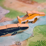 A Lanka Kade mosasurus wooden toy figure placed on a Wonderie plains of Africa play cloth. These wooden toy figures are part of a huge range of Lanka Kade fair trade, wooden toys available here at Babipur.