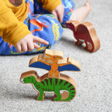 A child playing with Lanka Kade wooden toy dinosaur figures. The child is pointing at the Lanka Kade pteranodon figure. These wooden toy figures are part of a huge range of Lanka Kade fair trade, wooden toys available here at Babipur.