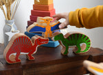 A child playing with Lanka Kade wooden toy dinosaur figures. The child is reaching for the Lanka Kade pteranodon figure. These wooden toy figures are part of a huge range of Lanka Kade fair trade, wooden toys available here at Babipur.