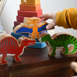 A child playing with Lanka Kade wooden toy dinosaur figures. The child is reaching for the Lanka Kade pteranodon figure. These wooden toy figures are part of a huge range of Lanka Kade fair trade, wooden toys available here at Babipur.