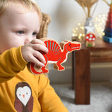 A child holding the Lanka Kade Wooden Spinosaurus Dinosaur in their hand. These wooden toy figures are part of a huge range of Lanka Kade fair trade, wooden toys available here at Babipur.