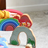 A child pointing at  the Lanka Kade Wooden Spinosaurus Dinosaur. These wooden toy figures are part of a huge range of Lanka Kade fair trade, wooden toys available here at Babipur.