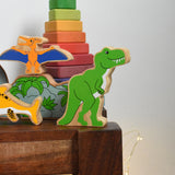 A Lanka Kade T Rex Dinosaur wooden toy figure placed on a small wooden table. These wooden toy figures are part of a huge range of Lanka Kade fair trade, wooden toys available here at Babipur.