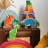 A collection of wooden dinosaurs from Lanka Kadeplaced on a small wooden table. These wooden toy figures are part of a huge range of Lanka Kade fair trade, wooden toys available here at Babipur.