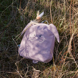 Lassig kids tiny bunny backpack on dry grass with decorative feathers clipped on the backpack with a peg