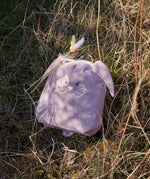Lassig kids tiny bunny backpack on dry grass with decorative feathers clipped on the backpack with a peg