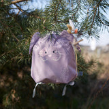Lassig kids tiny bunny backpack hanging on a tree by the loop handle on the top with decorative reeds clipped on the ear by a peg