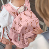 A child wearing the Lassig Mini Safari Giraffe kids backpack, as another child opens the zip.